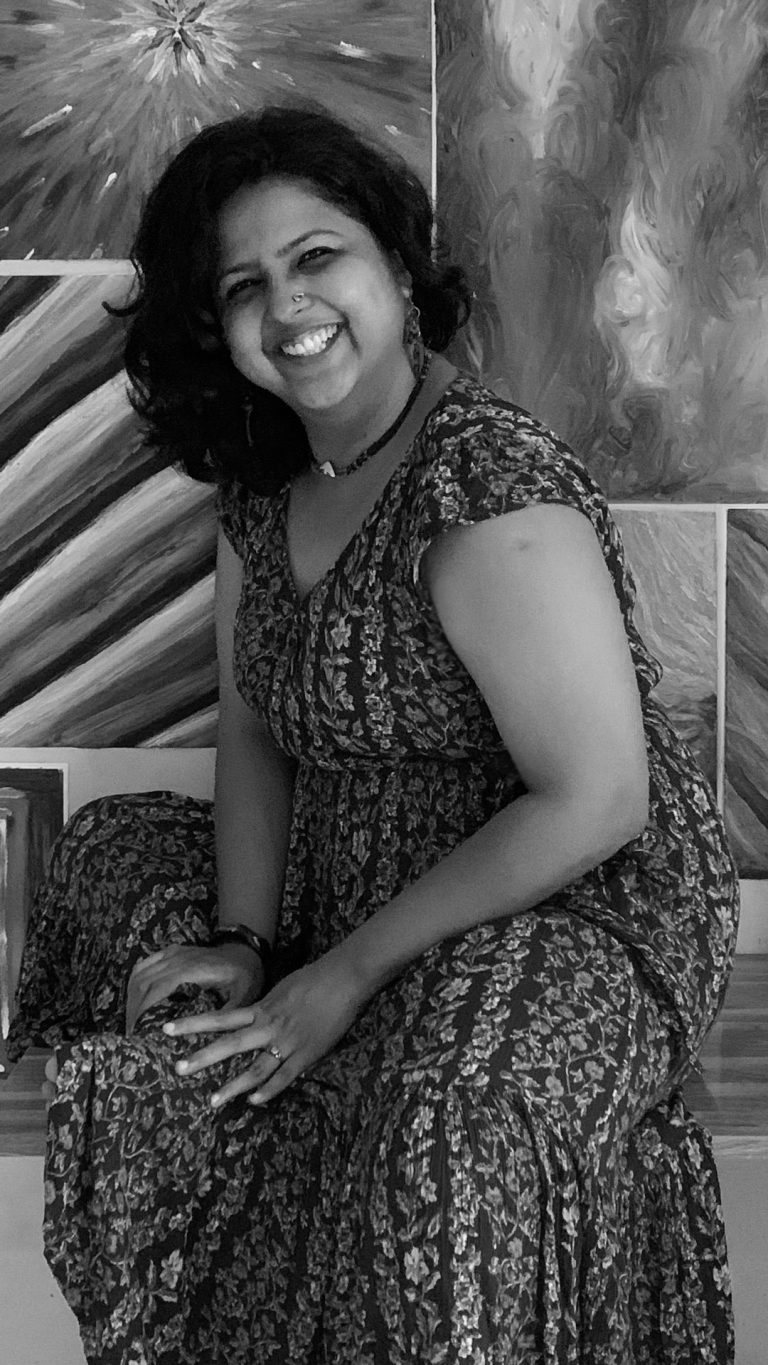 Arpita, a smiling person in a greyscale image, is a safe and brave space facilitator